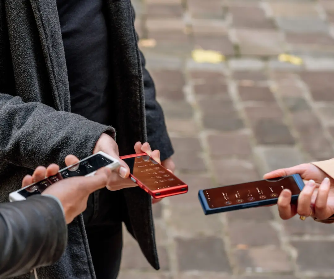 Tre vänner som glatt håller i sina översättare, samtalar och delar stunder tillsammans. 